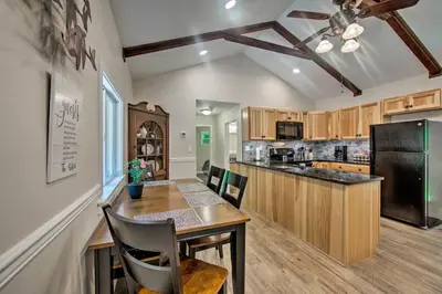 a kitchen with a table and a black refrigerator at Hike, Hunt and Unwind Cozy Cabin Near Hersheypark in Jonestown
