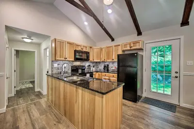 a kitchen with wooden cabinets and a black refrigerator at Hike, Hunt and Unwind Cozy Cabin Near Hersheypark in Jonestown