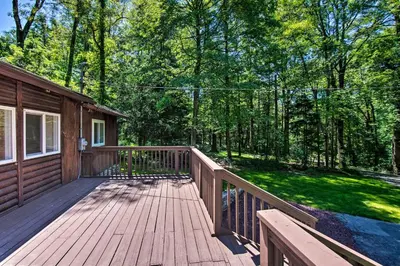 a wooden deck with a house and trees at Hike, Hunt and Unwind Cozy Cabin Near Hersheypark in Jonestown