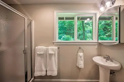 a bathroom with a shower and a sink and a mirror at Hike, Hunt and Unwind Cozy Cabin Near Hersheypark in Jonestown