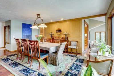 a dining room and living room with a table and chairs at Luxe Poconos Pines Home with Beach and Amenities! in Pocono Pines