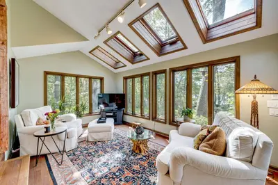 a living room with skylights and white furniture at Luxe Poconos Pines Home with Beach and Amenities! in Pocono Pines