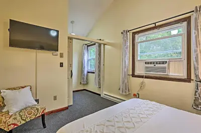 a bedroom with a bed and a tv on the wall at 15 Mi to Camelback Ski Resort Home with Deck! in Tobyhanna