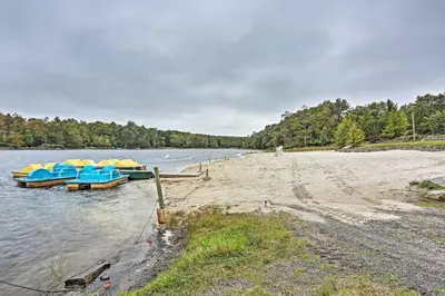 three boats are docked on the shore of a river at 15 Mi to Camelback Ski Resort Home with Deck! in Tobyhanna