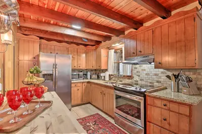 a kitchen with wooden cabinets and stainless steel appliances at Deck and Fire Pit Cozy Pocono Mountain Home in Lake Harmony