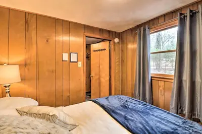 a bedroom with a bed and a window at Deck and Fire Pit Cozy Pocono Mountain Home in Lake Harmony