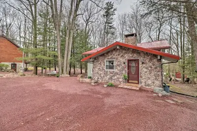 a small stone house with a red roof at Deck and Fire Pit Cozy Pocono Mountain Home in Lake Harmony