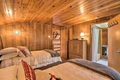 a bedroom with two beds and wooden walls at Deck and Fire Pit Cozy Pocono Mountain Home in Lake Harmony