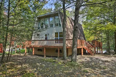 a large house with a deck in the woods at half Mi to Hideout Ski Lake Ariel Resort Home! in Lake Ariel