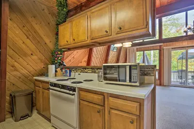 a kitchen with a stove and a microwave at half Mi to Hideout Ski Lake Ariel Resort Home! in Lake Ariel