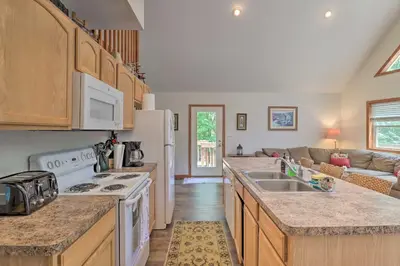 a kitchen with white appliances and a living room at Deck, Hot Tub and Game Room Lake Harmony Home in Lake Harmony