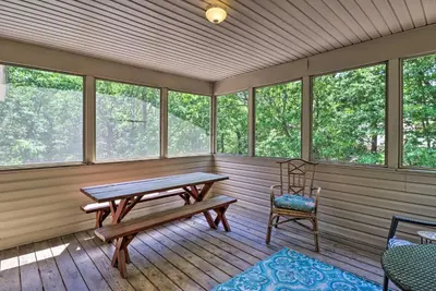 a screened in porch with a bench and a chair at Deck, Hot Tub and Game Room Lake Harmony Home in Lake Harmony