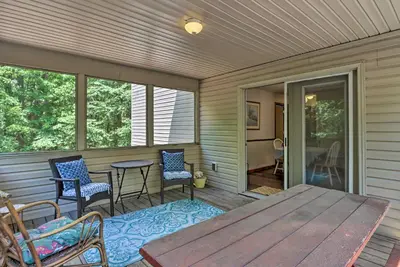 a screened in porch with a wooden table and chairs at Deck, Hot Tub and Game Room Lake Harmony Home in Lake Harmony