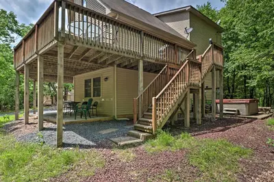 a house with a deck with a table and chairs at Deck, Hot Tub and Game Room Lake Harmony Home in Lake Harmony