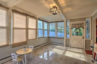 a room with a table and chairs and windows at Lake Hopatcong Family Home with Boat Slip and Dock in Hopatcong