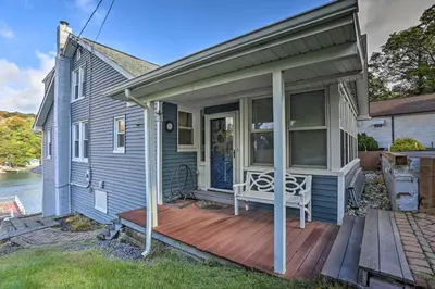 a blue house with a porch with a wooden deck at Lake Hopatcong Family Home with Boat Slip and Dock in Hopatcong