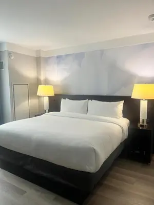 a bedroom with a large white bed with two lamps at Four Points by Sheraton New York Downtown in New York
