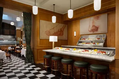 a restaurant with a counter with many trays of food at Le Meridien New York, Central Park in New York