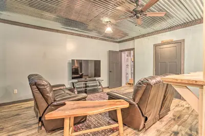 a living room with leather furniture and a flat screen tv at Palmerton Cabin with Game Room about 5 Mi to Blue Mtn in Palmerton