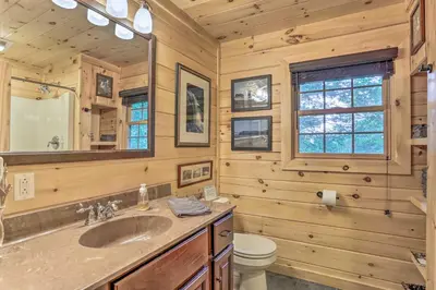 a bathroom with a sink and a toilet and a mirror at Palmerton Cabin with Game Room about 5 Mi to Blue Mtn in Palmerton