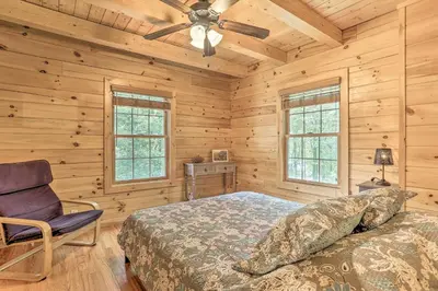 a bedroom with a bed and a chair in a cabin at Palmerton Cabin with Game Room about 5 Mi to Blue Mtn in Palmerton