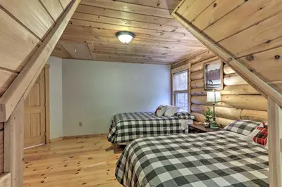 two beds in a room with wooden walls at Expansive Group Getaway 11 Mi to Lancaster! in New Providence