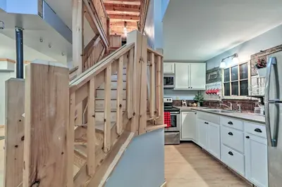 a kitchen with white cabinets and a wooden staircase at Expansive Group Getaway 11 Mi to Lancaster! in New Providence