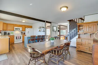 a kitchen and dining room with a wooden table and chairs at Near Skiing Lakefront Gem with Kayaks in Long Pond in Long Pond