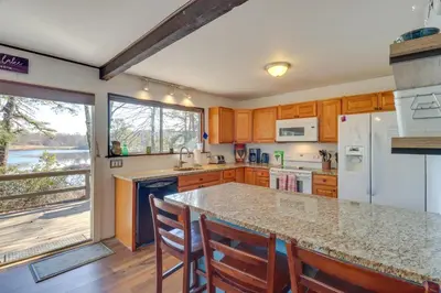 a kitchen with wooden cabinets and a large counter top at Near Skiing Lakefront Gem with Kayaks in Long Pond in Long Pond