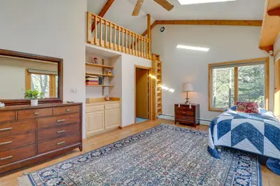 a bedroom with a bed and a dresser and a staircase at Near Skiing Lakefront Gem with Kayaks in Long Pond in Long Pond
