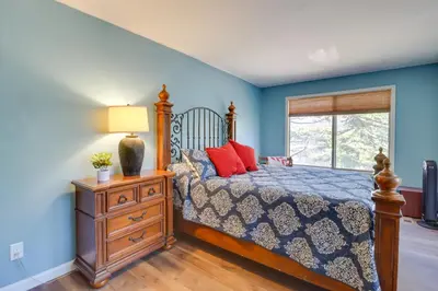 a bedroom with blue walls and a bed with red pillows at Near Skiing Lakefront Gem with Kayaks in Long Pond in Long Pond