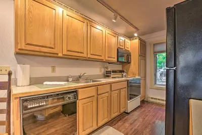 a kitchen with wooden cabinets and a black refrigerator at 1 Mi to Jack Frost Ski Resort Water-View Retreat in Lake Harmony