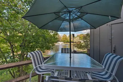 a table and two chairs with an umbrella on a porch at 1 Mi to Jack Frost Ski Resort Water-View Retreat in Lake Harmony