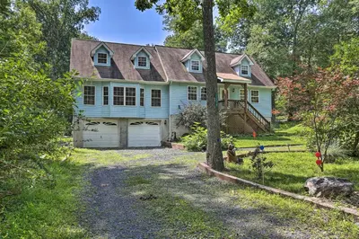 a blue house with a garage in the yard at 5 Mi to Camelback Henryville Home with Hot Tub! in Henryville