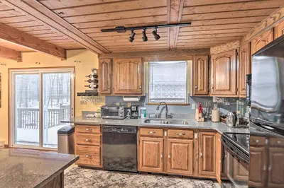 a kitchen with wooden cabinets and a sink at 5 Mi to Camelback Henryville Home with Hot Tub! in Henryville