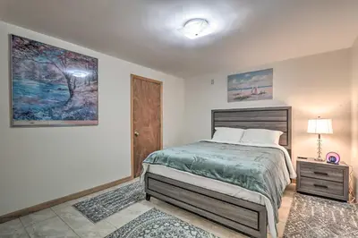 a bedroom with a bed and a lamp and a door at 5 Mi to Camelback Henryville Home with Hot Tub! in Henryville
