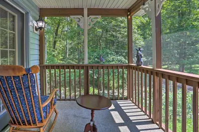 a screened in porch with a rocking chair and a table at 5 Mi to Camelback Henryville Home with Hot Tub! in Henryville