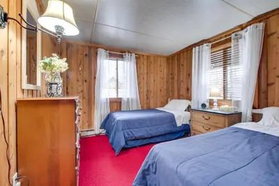 a bedroom with two beds and a red carpet at Fire Pit and Community Perks Gouldsboro Cabin! in Gouldsboro