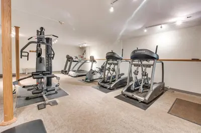 a gym with several tread machines in a room at Fire Pit and Community Perks Gouldsboro Cabin! in Gouldsboro