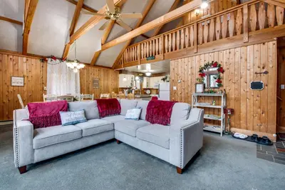 a living room with two couches and red pillows at Fire Pit and Community Perks Gouldsboro Cabin! in Gouldsboro