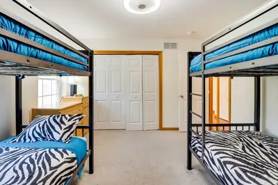 two bunk beds in a room with a hallway at Deck, Game Room and Fire Pit Poconos Retreat in Albrightsville