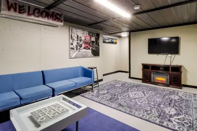a living room with a blue couch and a tv at Deck, Game Room and Fire Pit Poconos Retreat in Albrightsville