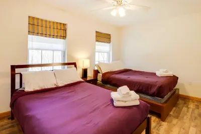 a bedroom with two beds and two windows at Deck, Game Room and Fire Pit Poconos Retreat in Albrightsville