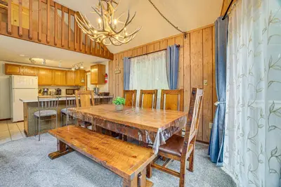 a dining room with a table and a kitchen at Fire Pit and Games! Secluded Chalet 30 Mi to Montage in Lake Ariel