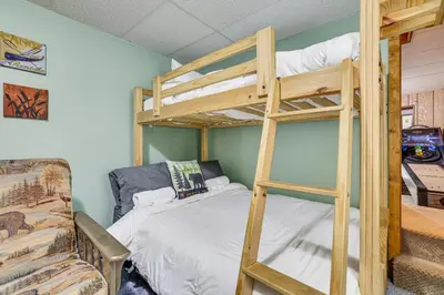 a bedroom with two bunk beds and a couch at Fire Pit and Games! Secluded Chalet 30 Mi to Montage in Lake Ariel
