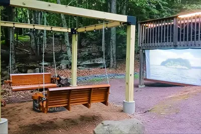 two benches chained to a swing in a park at Fire Pit and Games! Secluded Chalet 30 Mi to Montage in Lake Ariel