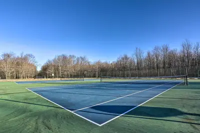 a tennis court with a net on top of it at Fire Pit and Games! Secluded Chalet 30 Mi to Montage in Lake Ariel