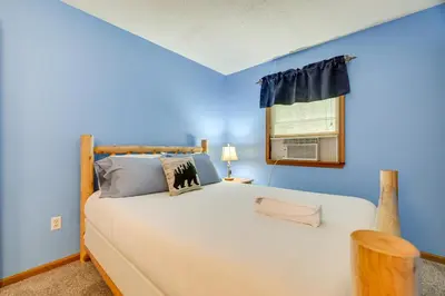a bedroom with a large bed with blue walls and a window at Secluded Family Cabin with Fire Pit in Lake Ariel! in Lake Ariel
