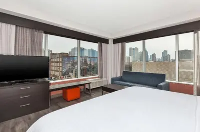 a hotel room with a bed and a large window at Holiday Inn Express & Suites Jersey City - Holland Tunnel by IHG in Jersey City