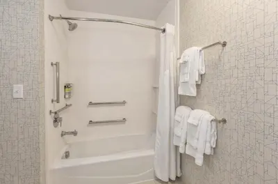 a bathroom with a shower with white towels at Holiday Inn Express & Suites Jersey City - Holland Tunnel by IHG in Jersey City